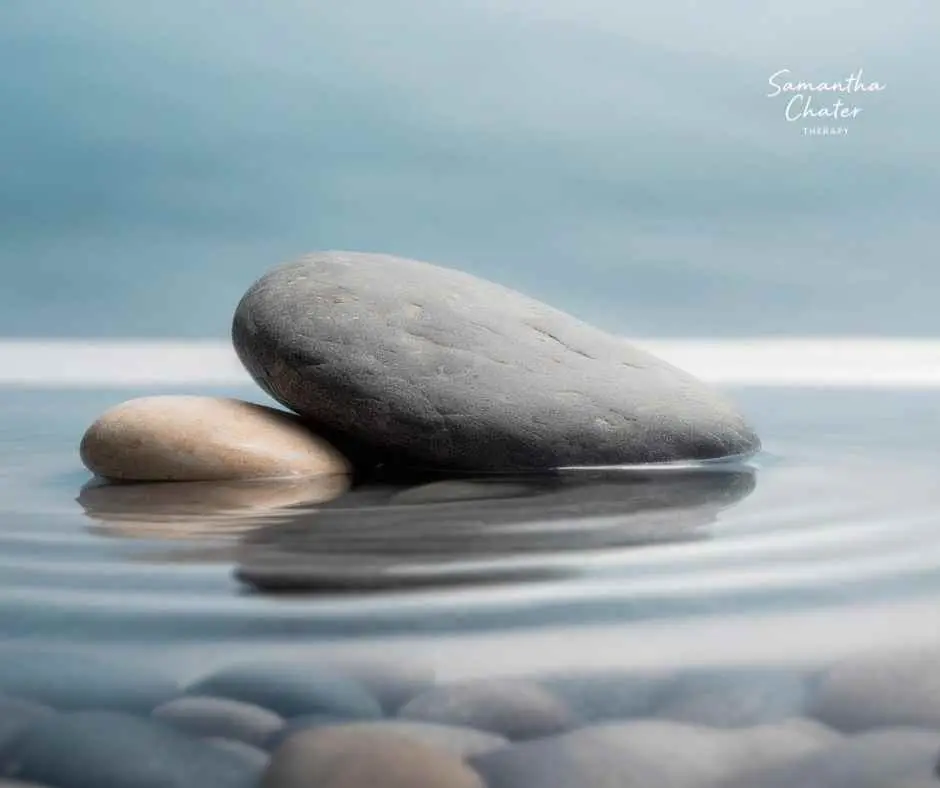 a pebble resting in calm water, symbolising relief from anxiety and a sense of grounding